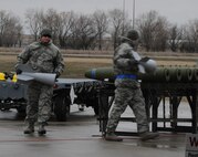 MINOT AIR FORCE BASE, N.D. -- Load crew members attach the fins to conventional bombs April 13 in a load crew competition here. The 5th Bomb Wing joined six other bomb wings in Air Force Global Strike Command’s first-ever load competition April 13 and 14 here. The evaluation was based not only on the Warbird’s hands-on skills, but also their knowledge in their respective career fields. (U.S. Air Force photo by Staff Sgt. Stacy Moless)