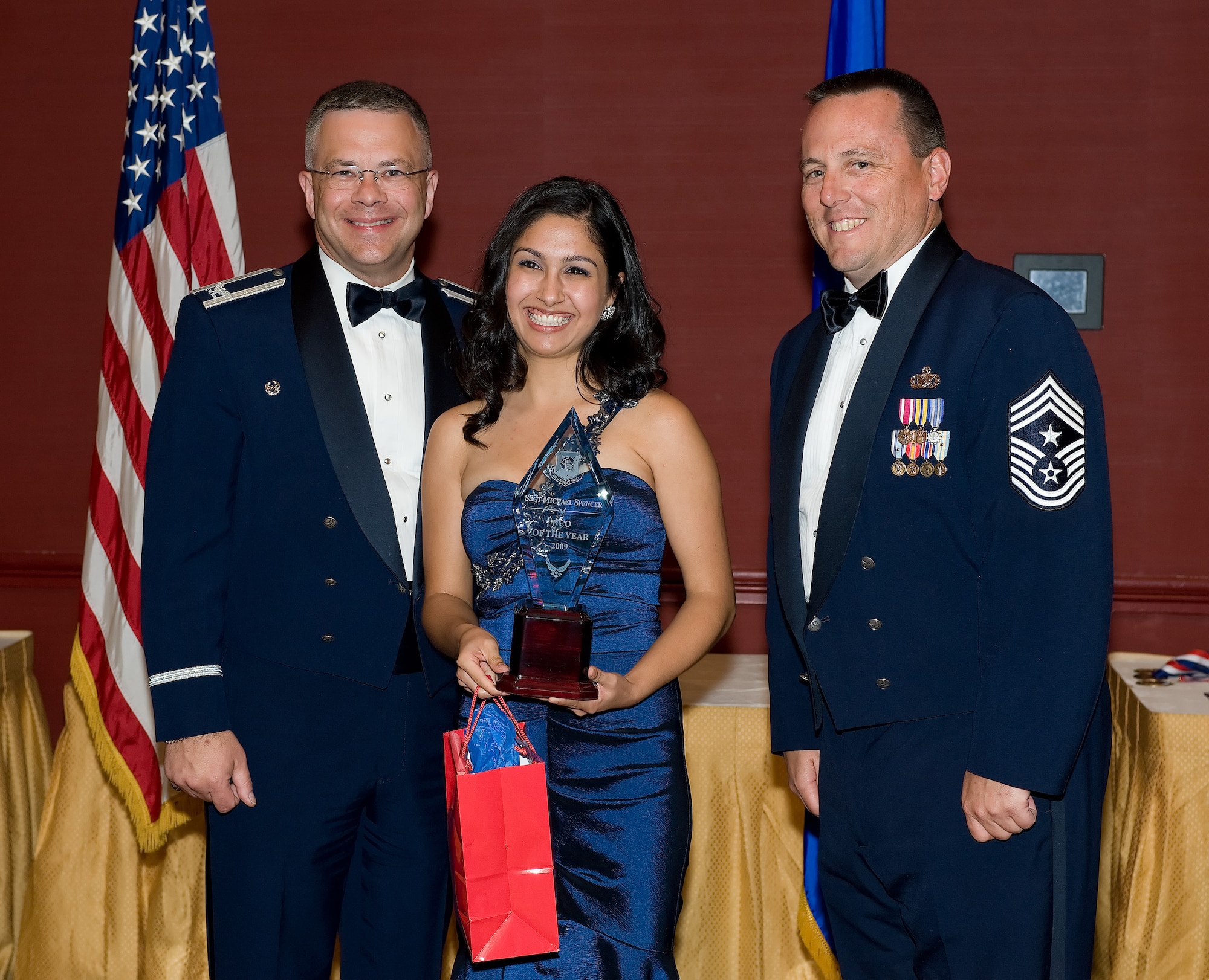 Jade Spencer, wife of Staff Sgt. Michael Spencer, 512th Logistics Readiness Flight, accepts her spouse's award from 512th Airlift Wing Commander Col. Randal L. Bright and Command Chief Master Sgt. William T. Wild III during the 512th AW Annual Awards Banquet April 10 at the Sheraton in Dover. Her husband is the 2009 512th Airlift Wing NCO of the second quarter and the 512th AW NCO of the Year. (U.S. Air Force photo/Jason Minto) 