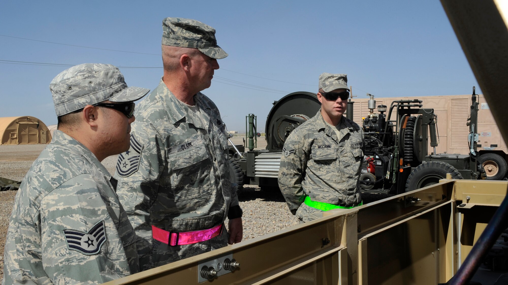 HOLLOMAN AIR FORCE BASE, N.M. -- Chief Master Sgt. Harold Clark, 12th Air Force command chief, looks at a primary switching center with Airman 1st Class Christopher McCann and Staff Sergeant Robert Her, with the 49th Materiel Maintenance Group, at Holloman?s Basic Expeditionary Airfield Resources, April 6, 2010. Airmen from the 49th MMG presented Chief Clark with displayed structures of heating and cooling, kitchens, showers, latrines, and high-voltage power generators for an 1100-person encampment. (U.S. Air Force photo by Airman 1st Class Veronica Stamps / Released)