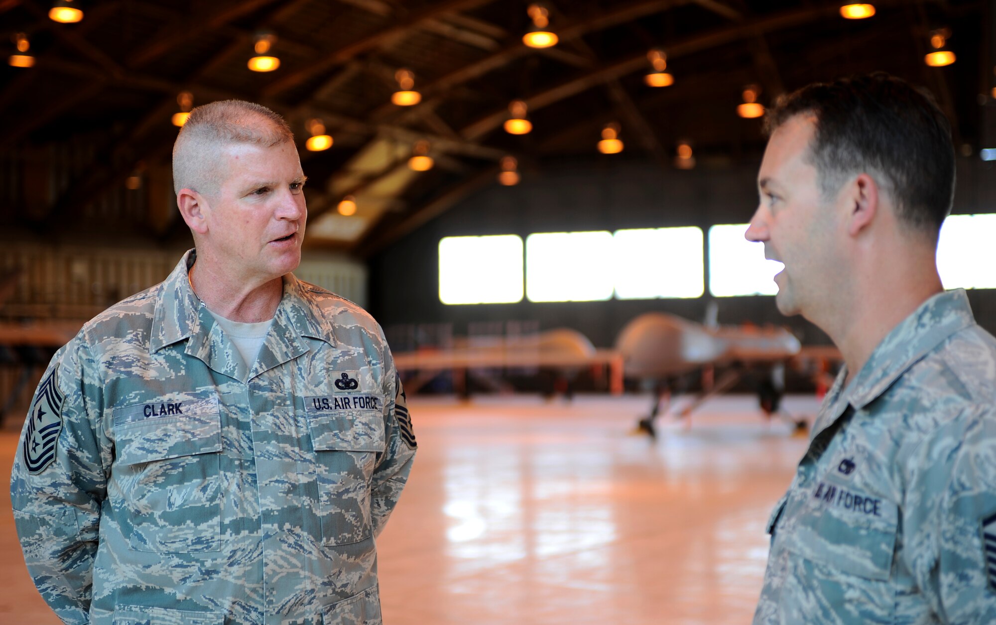 HOLLOMAN AIR FORCE BASE, N.M. -- Chief Master Sgt. Harold Clark, 12th Air Force command chief, speaks with Master Sgt. Timothy Servati, 849th Aircraft Maintenance Squadron superintendent April 6, 2010. Sergeant Servati gives Chief Clark a tour of Holloman?s historic hangar 301 that now houses the remotely piloted aircraft and introduces the Airmen that maintain the aircraft. (U.S. Air Force photo by Airman 1st Class Veronica Stamps / Released)