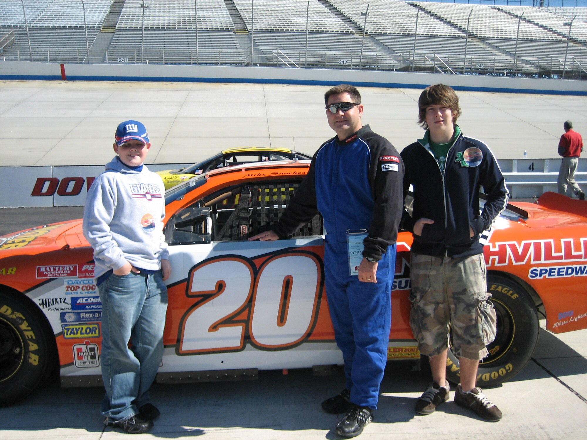 DOVER, Del. -- Colonel Webb (center), and his sons, Dock (left) and Michael (right) in front of Nascar driver, Tony Stewart’s, car at Dover Speedway in October 2006.  While at Dover Speedway, he got the opportunity to drive on the track two laps with an instructor driver and then ten laps on his own against other drivers.  The colonel has also been in the pit area for several races as a part of the Air Force Racing sponsorship managed by the AF recruiting office.Courtesy photo