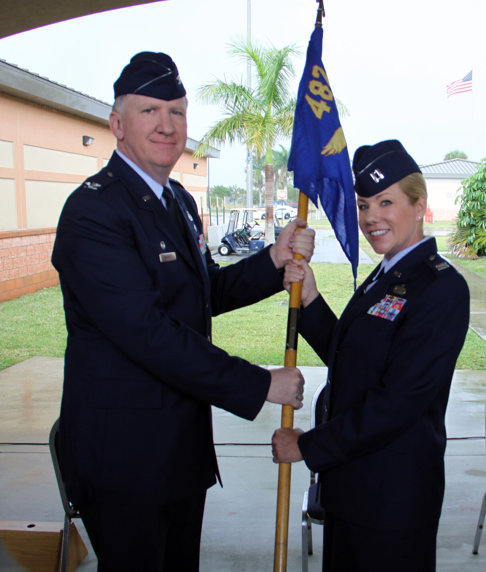 Col. Michael J. McCully passes the squadron guidon to Capt. Katherine A. Easevoli, 482nd Communications Squadron commander on April 11.  Capt. Easevoli assumed command from Maj. Richard C. Ropac during a brief change-of-command ceremony at Homestead Air Reserve Base, Fla. (U.S. Air Force photo/Senior Airman Lou Burton)