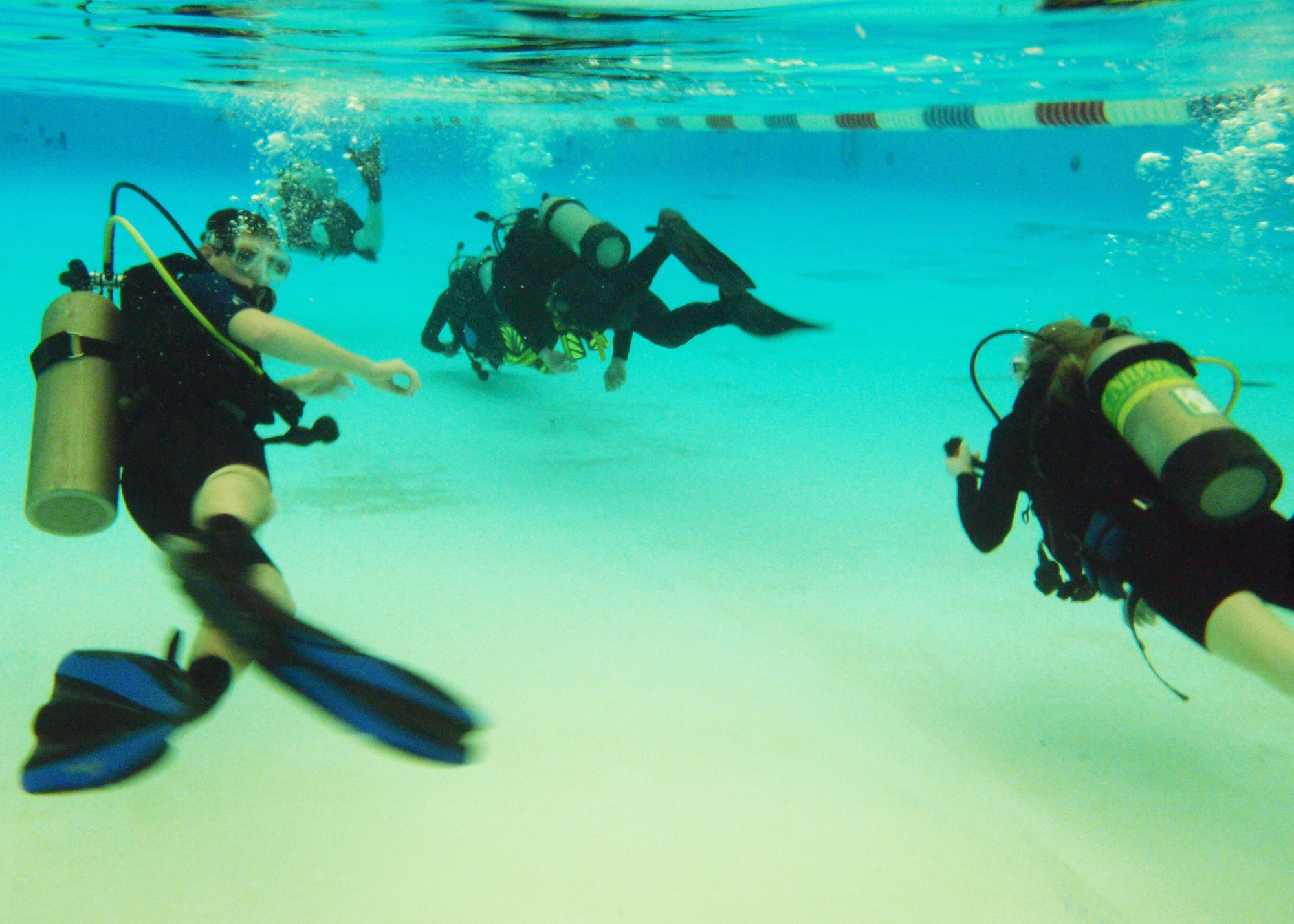 Students (right) swim with scuba gear for the first time as an instructor (left) watches during Day 2 of the certification course taught here at Eglin.  The class is four days over two weekends and it occurs once a month.  After taking the course, students will be certified to dive in up to 60 feet of water.  Anyone interested in attending the class, can call 850-217-1261.  (U.S. Air Force photo/Samuel King Jr.)