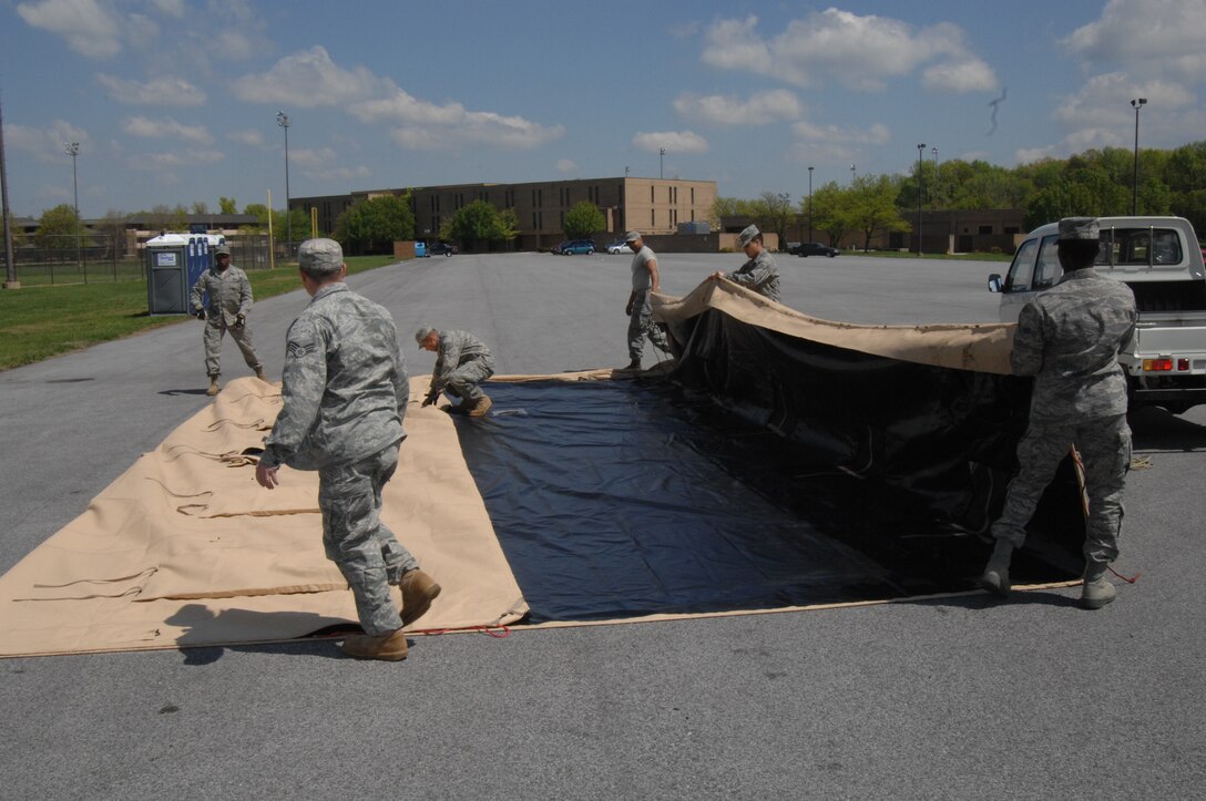 Members of the 316th Civil Engineer Squadron fold the cover from a small shelter system personnel tent for storage at Joint Base Andrews, Md., April 14, 2010. Members of the 316 CES broke the tent and other temporary locations around base down that supported Andrews staff working during Nuclear Security Summit. The 316th Wing led Joint Base Andrews in providing a transition location for a number of foreign national leaders arriving from around the world in attendance of the summit.  (U.S. Air Force photo by Staff Sgt. Christopher Marasky)