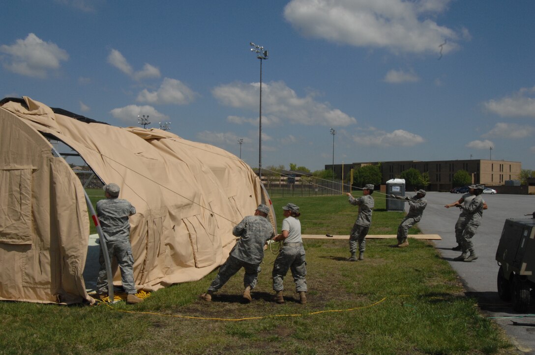 Members of the 316th Civil Engineer Squadron remove the cover from a small shelter system personnel tent at Joint Base Andrews, Md., April 14, 2010. Members of the 316 CES broke the tent and other temporary locations around base down that supported Andrews staff working during the Nuclear Security Summit. The 316th Wing led Joint Base Andrews in providing a transition location for a number of foreign national leaders arriving from around the world in attendance of the summit.  (U.S. Air Force photo by Staff Sgt. Christopher Marasky)