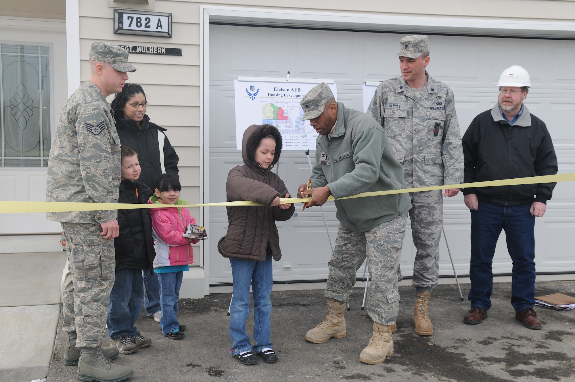 Camrynn Mulhern cuts the ribbon with Col. Karlton Johnson April 9, 2010, Eielson Air Force Base, Alaska. The Mulherns became the first family to move into the new junior enlisted housing in Century Park North neighboorhood. Colonel Johnson is the 354th Mission Support Group commander. Camerynn is the daughter of Hugh Mulhern, assigned to the 354th Logistics Readiness Squadron. (U.S. Air Force photo/Airman 1st Class Janine Thibault).