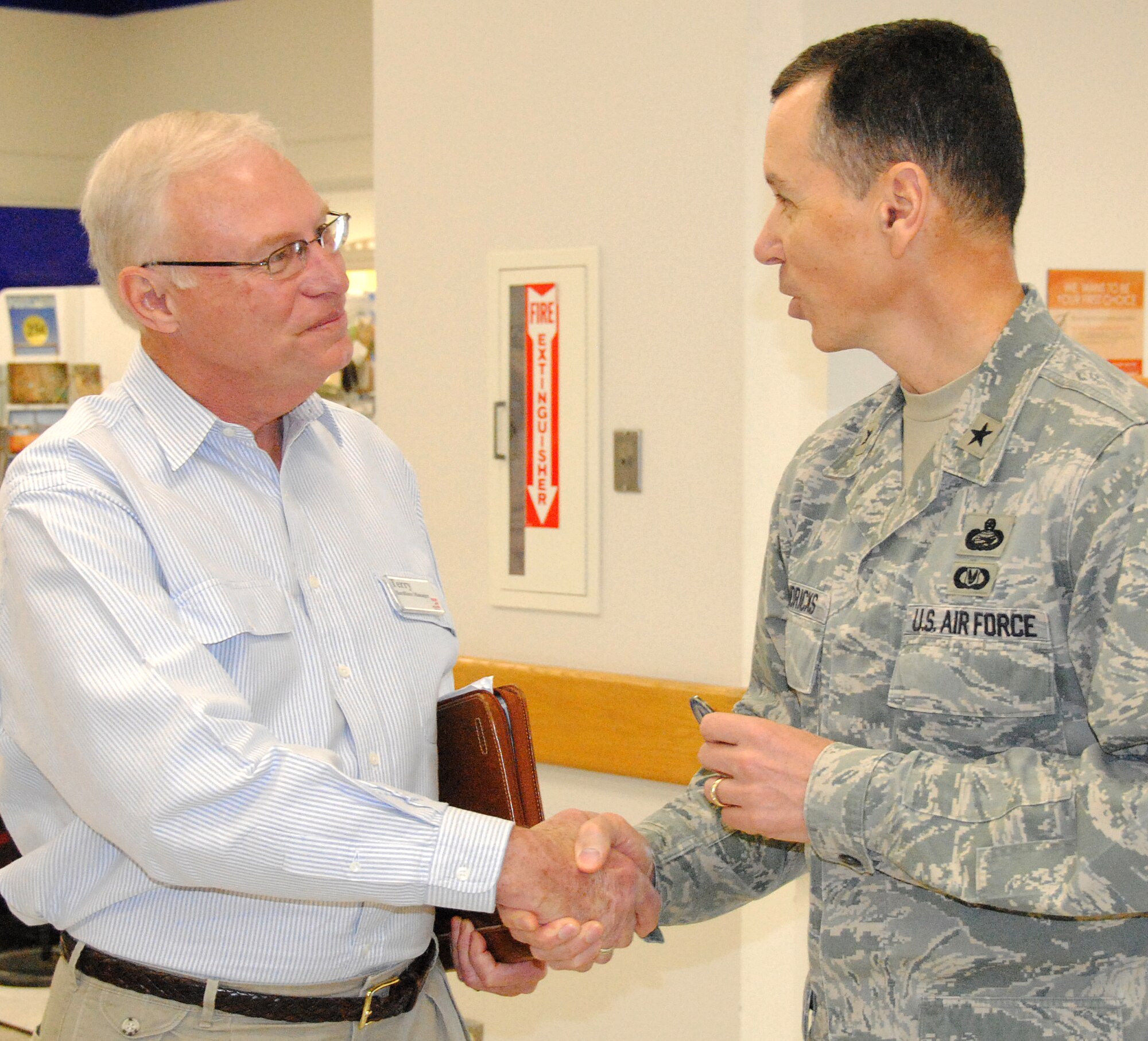 Brig. Gen. Francis Hendricks, deputy commander of the Army Air Force Exchange Service, right, presents an AAFES coin to Terry Lewis, a department manager at the Vance AFB base exchange. The general said Mr. Lewis certainly deserved the coin, based on his leadership, dedication to customer service and his design concept for the new furniture department. General Hendricks was at Vance April 9 to tour the exchange and meet local leadership. (U.S. Air Force photo/ Joe B. Wiles)