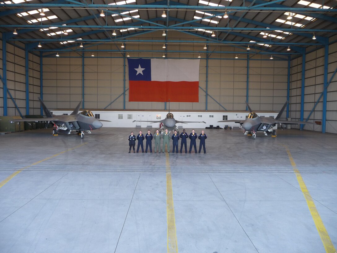 SANTIAGO, Chile -- Air Combat Command's F-22 Raptor Demonstration Team pose for a media photo opportunity in front of Chilean Air Force F-16 and two F-22 Raptors.  The Demonstration Team performed during the FIDAE air and trade show in Santiago, Chile 20-28 March.  Also during the event, the team met with local community leaders, hosted children from various charitable organizations and visited a hospital for ill children. 