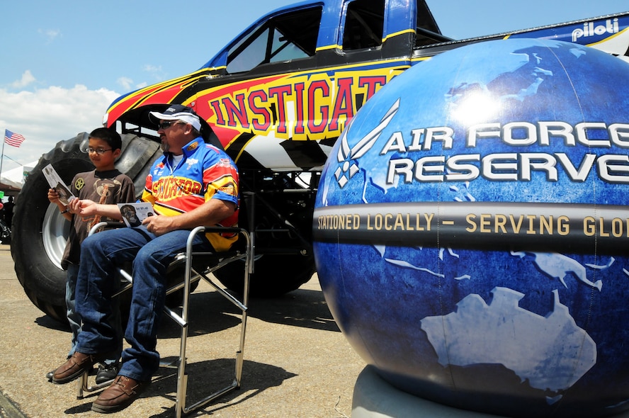 Lionel Easler, driver of the "The Instigator" monster truck poses with fans beside the Air Force Reserve display April 11 at the Eglin Air Force Base 75th Anniversary Airshow.  More than 125,000 were in attendance during the air show April 10-11, enjoying a variety of aerial performances and static displays. This was Eglin’s first open house since 2007 and was timed to coincide with the 75th anniversary of the installation. The Thunderbirds, F-22A Raptor demo and “Tora, Tora, Tora” were some of the highlights of the event.  (U.S. Air Force photo/Tech. Sgt. Samuel King Jr.) 
