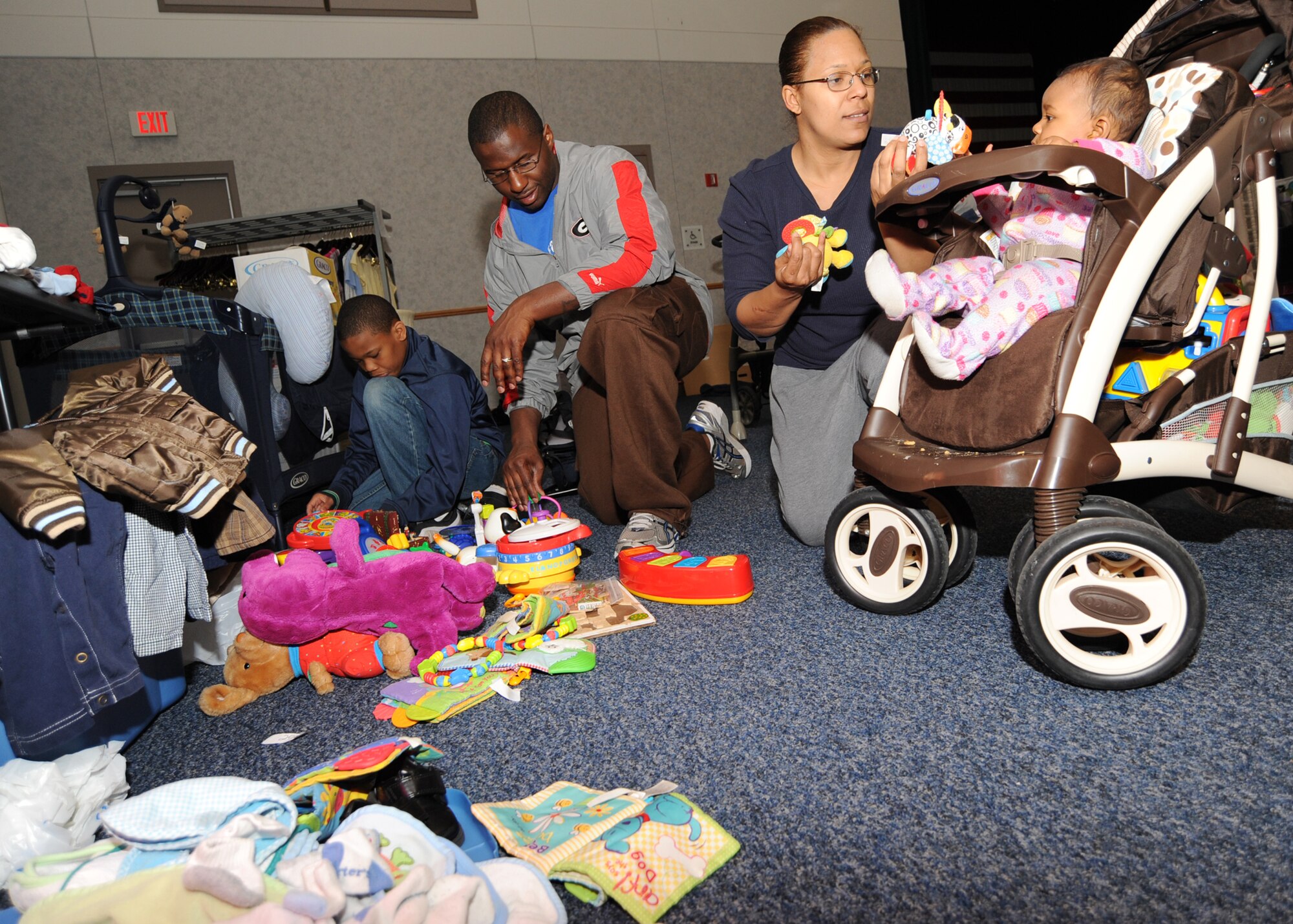 MCCONNELL AIR FORCE BASE, Kan. -- Staff Sgt. Larry Furlough, 22nd Operations Support Squadron airfield management, wife Alexis and children Jeremy, 10, and Isabelle, 8-months-old, shop for toys during the Mom-2-Mom sale at the Robert J. Dole Community Center ballroom, McConnell Air Force Base, Kan. The sale allowed Team McConnell members to sell maternity and children’s clothes, toys and furniture to fellow Team McConnell Airmen and their families.  (U.S. Air Force Photo/Senior Airman Maria Ruiz)