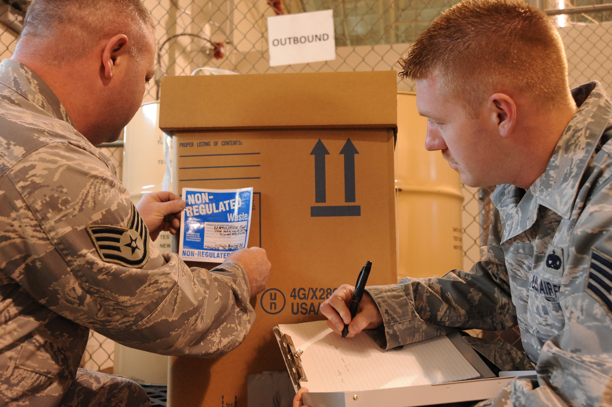 MCCONNELL AIR FORCE BASE, Kan. -- Staff Sgt. Cloyce Smith, 22nd Aircraft Maintenance Squadron hazardous material manager, places a non-regulated sticker on a box as Staff Sgt. James Lucas, 22nd Maintenance Group environmental coordinator, observes the process at McConnell Air Force Base, Kan., April 9, 2010. Team McConnell’s environmental and bio-environmental programs were inspected by an Air Mobility Command team and a contractor to ensure the programs were in compliance with state and federal standards EPA. McConnell’s maintenance group consists of more than 60 percent of the bases environmental and bio-environmental programs. The 22nd Aircraft Maintenance Squadron had zero defects found during the six-day Environmental, Occupational Health Compliance Assessment & Management Program inspection which was April 4 to 9. (U.S. Air Force photo/Tech. Sgt. Chyrece Campbell)