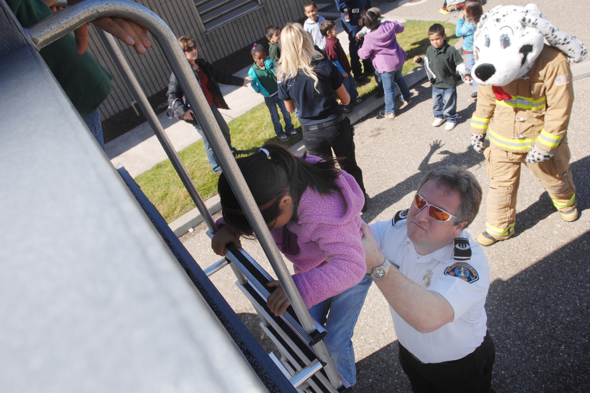 VANDENBERG AIR FORCE BASE, Calif. – Jim Mclean, a 30th Civil Engineer fire inspector assists a Manzanita Elementary School student climb down a ladder during the 9-1-1 For Kids event here Tuesday, April 13, 2010. The event was designed to help educate children from kindergarten to third grade on fire safety and how to dial 9-1-1 in the event of an emergency. (U.S. Air Force photo/Senior Airman Christopher Hubenthal) 