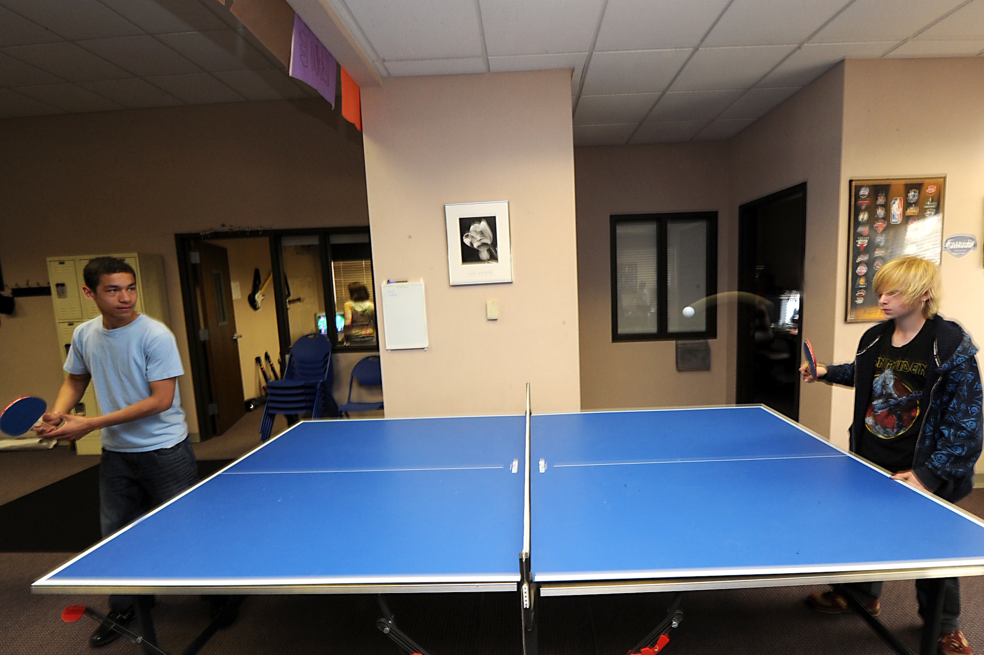Justin Perez, 13, son of Capt. Miguel Rivera, 62nd Airlift Squadron; and William Millien, 11; play a game of table tennis against one another at the Teen Center March 24. The facility offers table-top games, such as foosball, table tennis and billiards for the teens. (U.S. Air Force photo by Senior Airman Ethan Morgan)