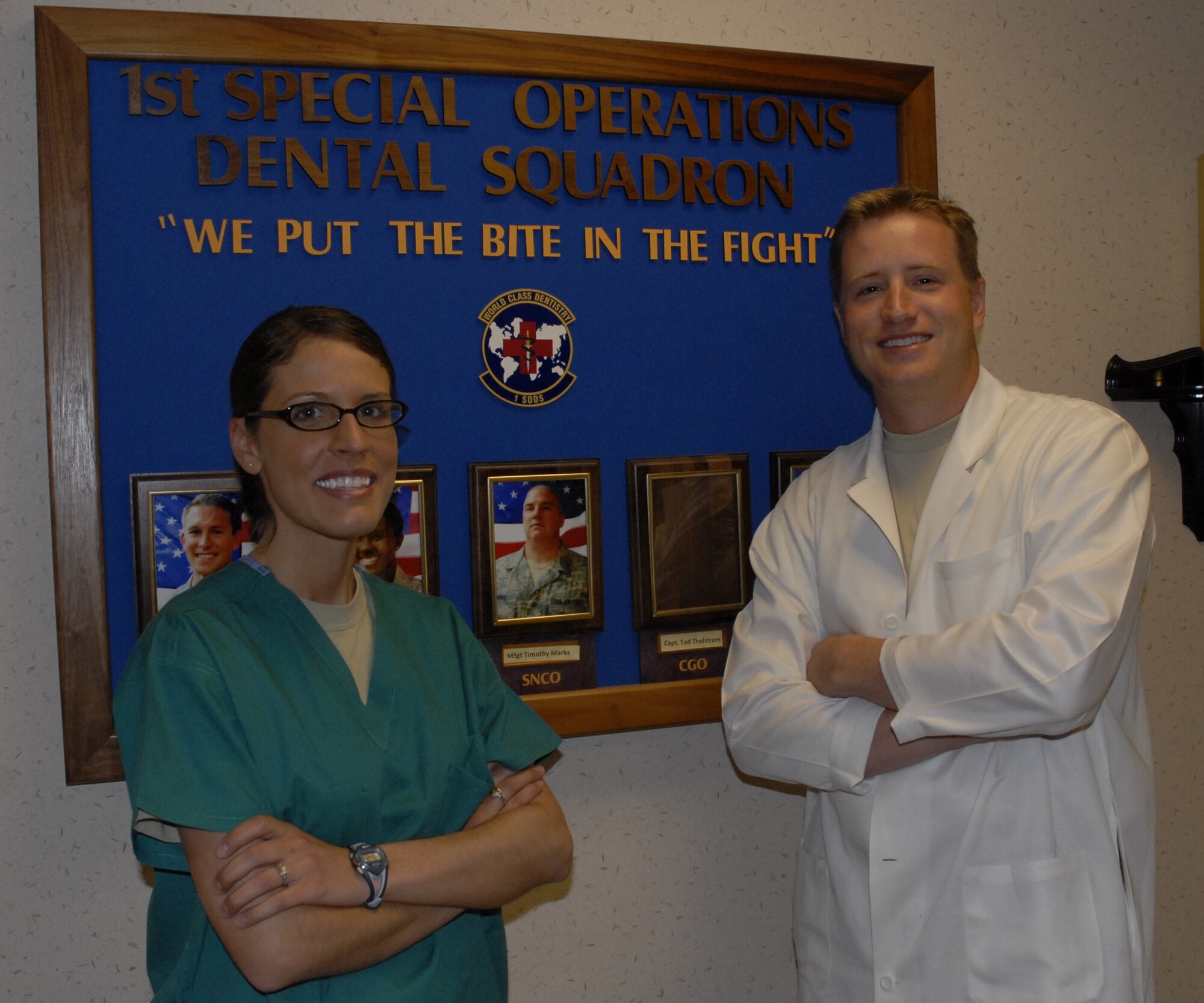 Capt. Tad Tholstrom, 1st Special Operations Dental Squadron general dentist, right, and Staff Sgt. Leah Potter, 1st SODS assistant NCOIC of dental readiness, pose in front of the 1st SODS logo at the Hurlburt Field dental clinic April 7. Captain Tholstrom and Sergeant Potter were selected for this week's "Tip of the Spear" spotlight. (U.S. Air Force photo by Airman 1st Class Joe McFadden)