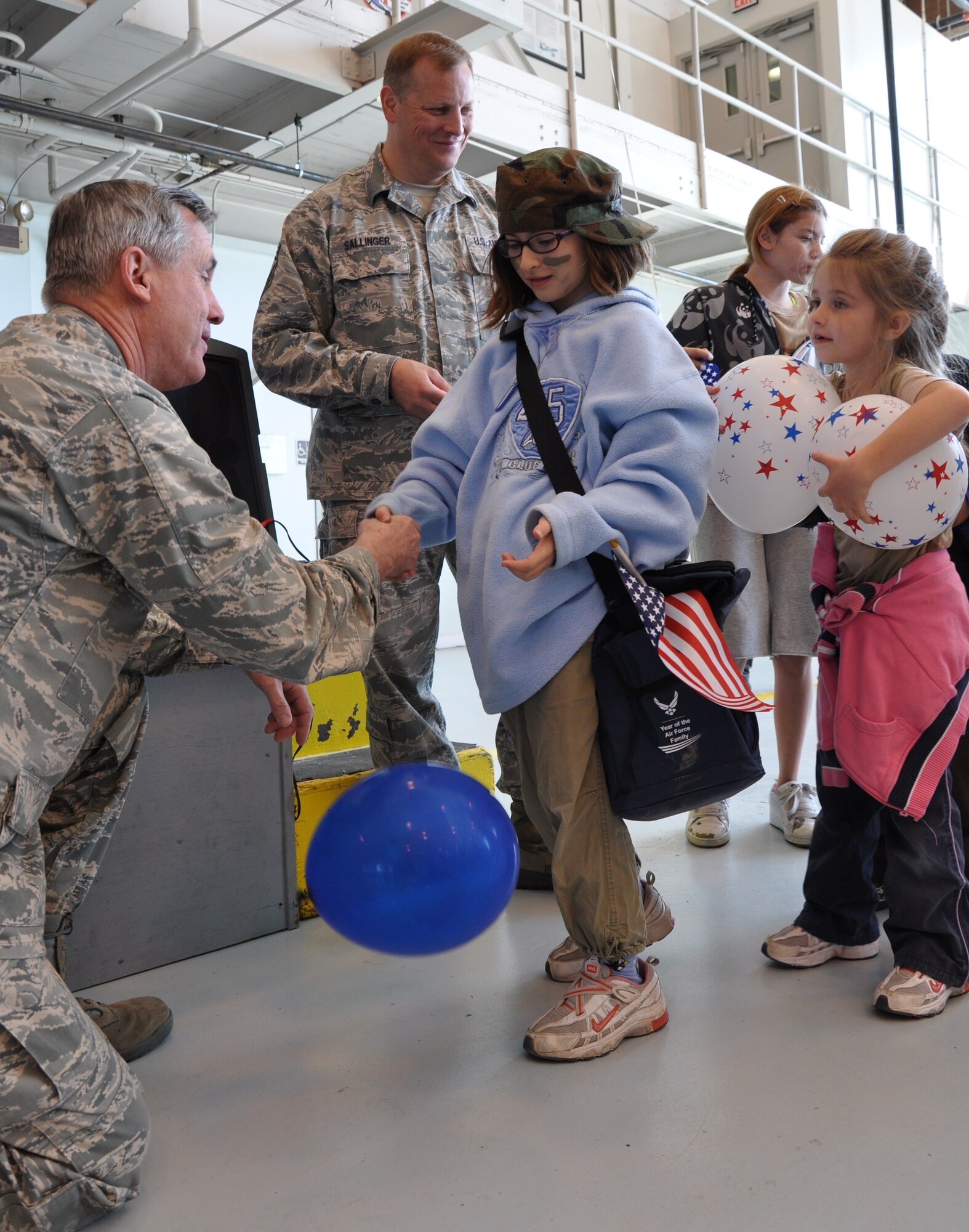 Children are presented a coin at the end of the Operation KIDS event by Brig. Gen. O.G. Mannon, 82nd Training Wing commander (left), and Chief Master Sgt. Kenneth Sallinger, 82nd TRW command chief, April 10. (U.S. Air Force Photo / Airman 1st Class Adawn Kelsey)