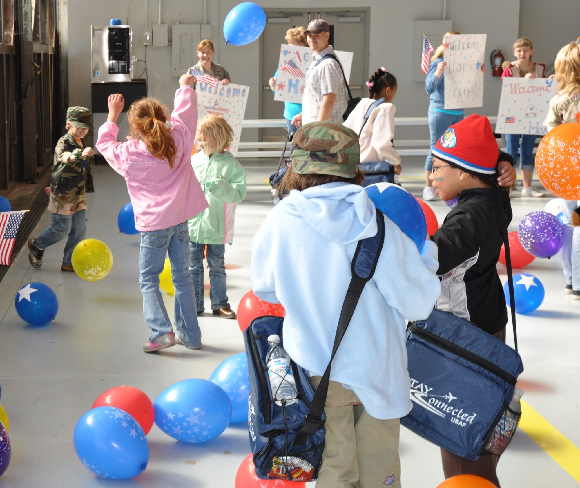 As children return from their deployment, they are met with a welcoming party during Operation KIDS April 10. The children were greeted with welcome home signs, balloons and smiles. (U.S. Air Force Photo/Airman 1st Class Adawn Kelsey) 
