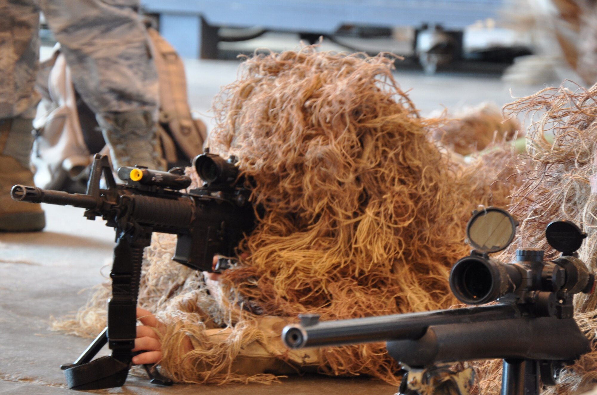 Children try on desert-colored Ghillie Suits and learn about weapons at the 82nd Security Forces Squadron exhibit during Operation KIDS April 10. The children learned that Ghillie Suits are worn to reduce the visibility of the silhouette of a person’s body and help blend with the desert colors.  (U.S. Air Force Photo/ Airman 1st Class Adawn Kelsey)
