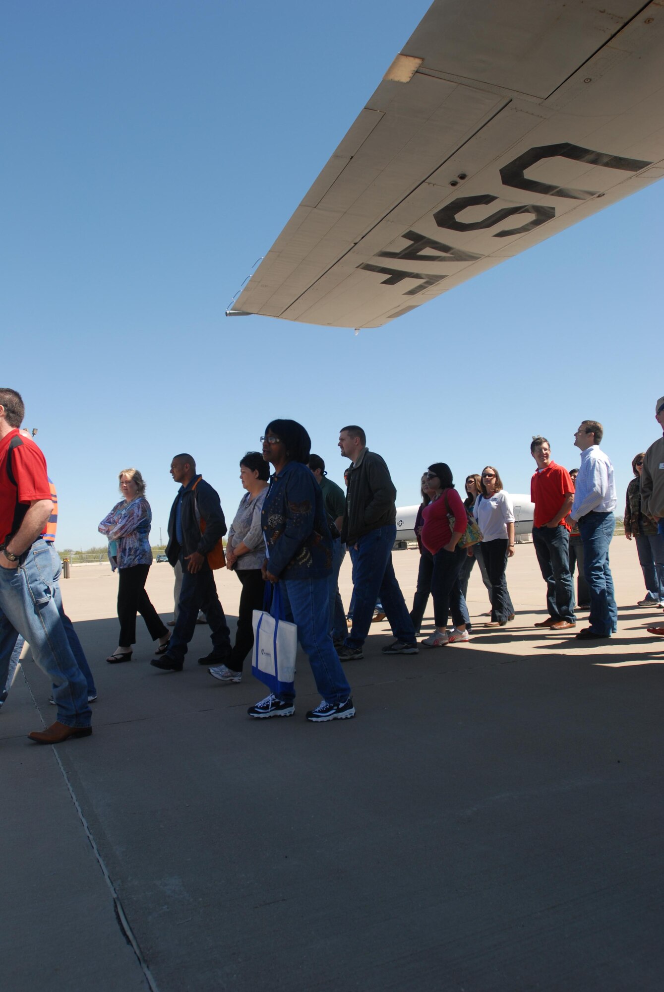 GOODFELLOW AIR FORCE BASE— More than 30 members of Leadership San Angelo, walk under the wing of a C-130 aircraft that is used for training, at the Louis F. Garland Department of Defense Fire Academy, April 8. The group was given a tour of the fire academy to better understand how firefighters train to fight different types of fires. (U.S. Air Force photo/ Senior Airman Tong Duong)