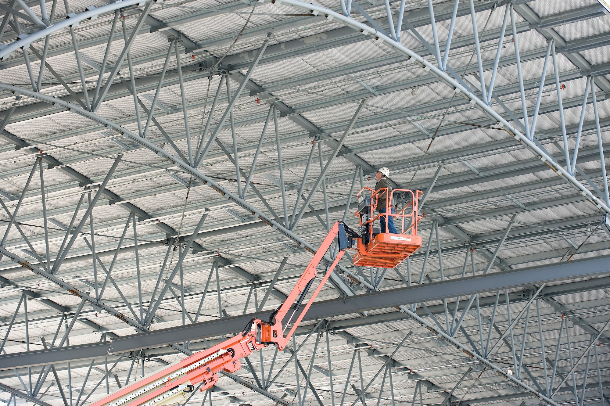 A Handling Services Inc. employee checks on a Mobile Tail Enclosure as it is stood up April 10.  Previously when a C-5 Galaxy was parked in a hanger the tail would be outside the hangar.  If winds were greater than 25 knots, maintenance couldn?t be performed on the aircraft.  The new MTE will cover the tail of the aircraft and allow service members to work on the aircraft even during inclimate weather.  (U.S. Air Force photo/Jason Minto)