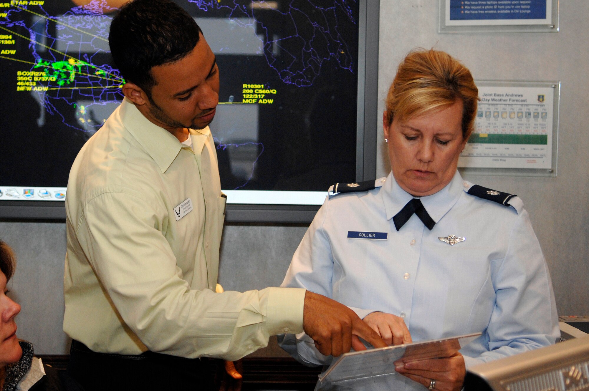 Gerome Banks, 316th Wing Protocol specialist, left, and Lt. Col. Michelle Collier, 459th Air Refueling Wing Protocol officer, right, discuss the departure schedule for the next two days for attendees of the Nuclear Security Summit leaving from Joint Base Andrews, Md., April 13, 2010.  The 316 WG is leading operations to provide safe, effective and efficient departure services for the invited guests transiting Andrews. (U.S. Air Force photo by Airman 1st Class Melissa V. Brownstein)