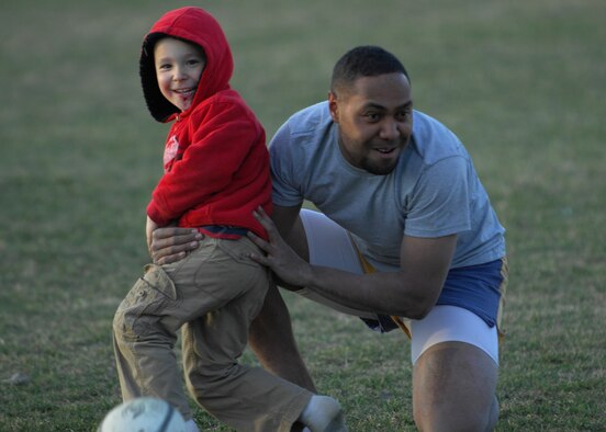 MINOT, N.D. -- Caleb Goeddertz, son of Staff Sgt. James Goeddertz, 5th Security Forces Squadron unit security manager, runs into Kelepi Rakabikabi, Minot resident, for a tackle at Jim Hill Middle School in Minot April 8. The team allows members to bring their children, and even sometimes teaches the children how to play the game as well. (U.S. Air Force photo by Airman 1st Class Ashley N. Avecilla)