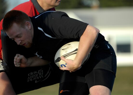 MINOT, N.D -- Carson Blair, Minot resident and member of the Minot rugby team, runs into an opponent during a rugby practice session at Jim Hill Middle School in Minot April 8. The team accepts anyone who is interested in playing rugby and will take the time to teach them how to play. (U.S. Air Force photo by Airman 1st Class Ashley N. Avecilla)