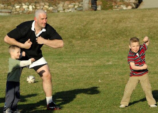MINOT, N.D. -- Staff Sgt. James Goeddertz, 5th Security Forces Squadron unit security manager, and his sons, Declan and Caleb Goeddertz, warm-up for rugby practice at the Jim Hill Middle School in Minot April 8. The Minot rugby team is a family friendly team that encourages team work and learning. (U.S. Air Force photo by Airman 1st Class Ashley N. Avecilla)