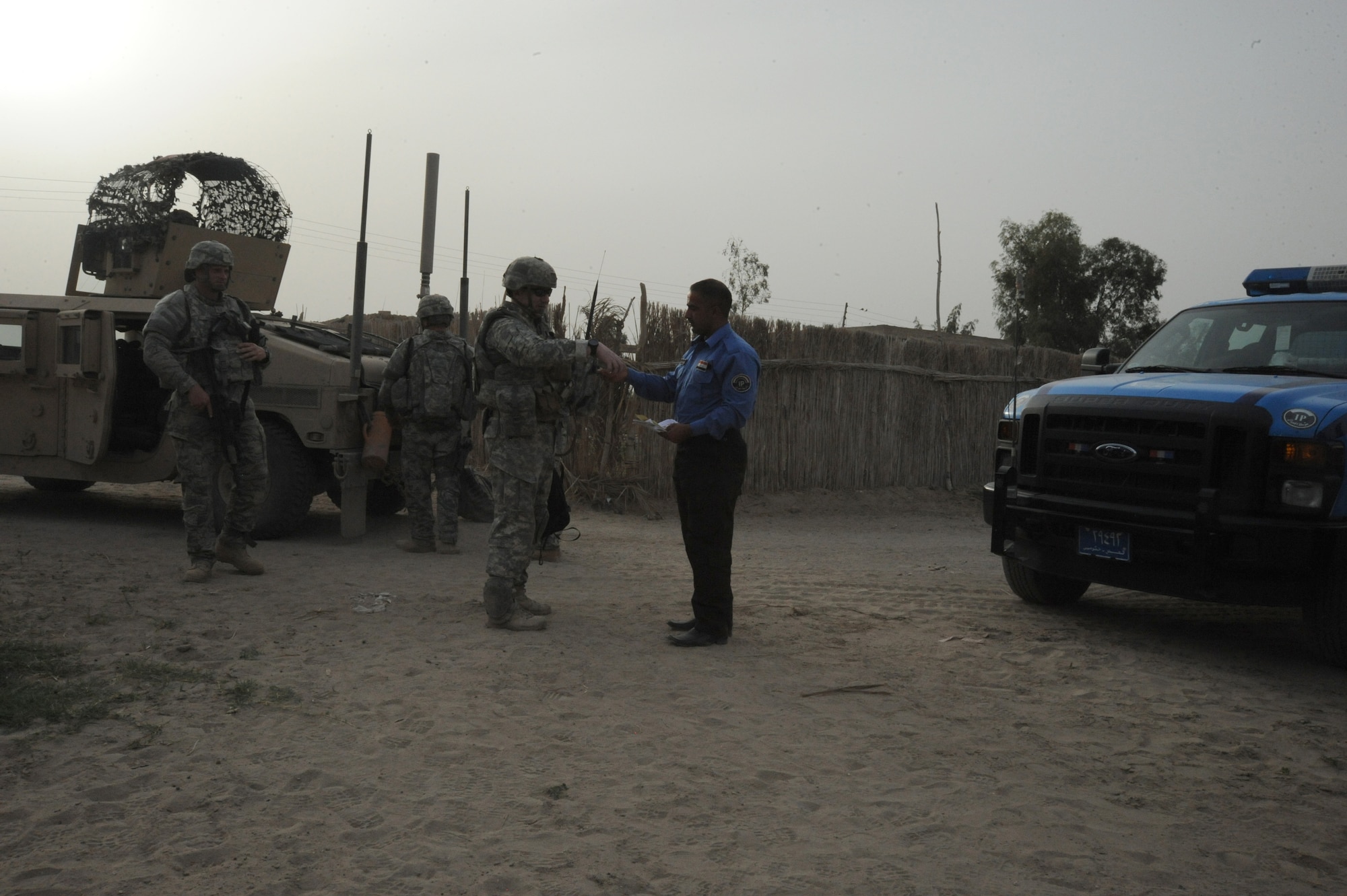 Members of the 732nd Expeditionary Security Forces Squadron, Detachment 2, hand an Iraqi police officer pamphlets to hand out after a joint presence patrol near Rufush, Iraq, April 4, 2010.  The pamphlets will be used for community police to provide information to the public about the local Iraqi Police to help build rapport with the community. (U.S. Air Force photo/Master Sgt. Trish Bunting/Released)