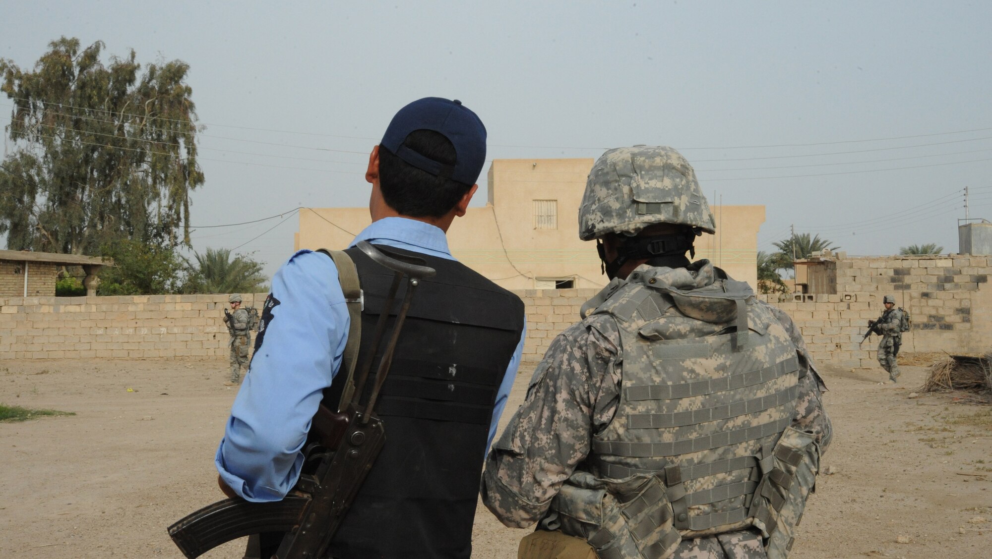 A U.S. Air Force member and a local Iraqi Police officer discuss recent attacks during a joint presence patrol near Rufush, Iraq, April 4, 2010.  The 732nd Expeditionary Security Forces, Detachment 2, conducted a “training and mentoring” mission, which was requested by the local police. During this mission, Air Force personnel trained the police in community policing and assisted with patrolling through a village recently overwhelmed by terrorist attacks.  (U.S. Air Force photo/Master Sgt. Trish Bunting/ Released)