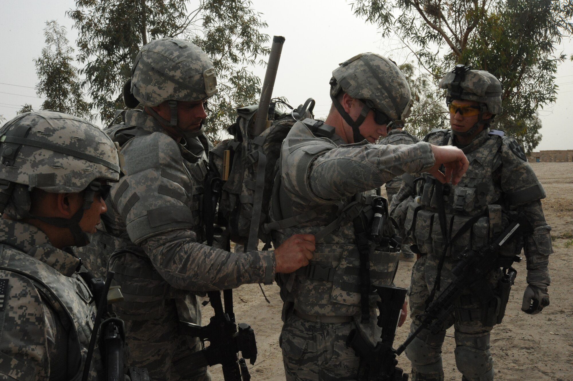 Members of the 732nd Expeditionary Security Forces Squadron, Detachment 2, assist Senior Airman Sean Boes with adjusting his equipment before beginning a joint presence patrol near Rufush, Iraq, April 4, 2010. The 732nd Expeditionary Security Forces, Detachment 2, conducted a “training and mentoring” mission, which was requested by the local police. During this mission, Air Force personnel trained the police in community policing and assisted with patrolling through a village recently overwhelmed by terrorist attacks.  (U.S. Air Force photo/Master Sgt. Trish Bunting/Released)