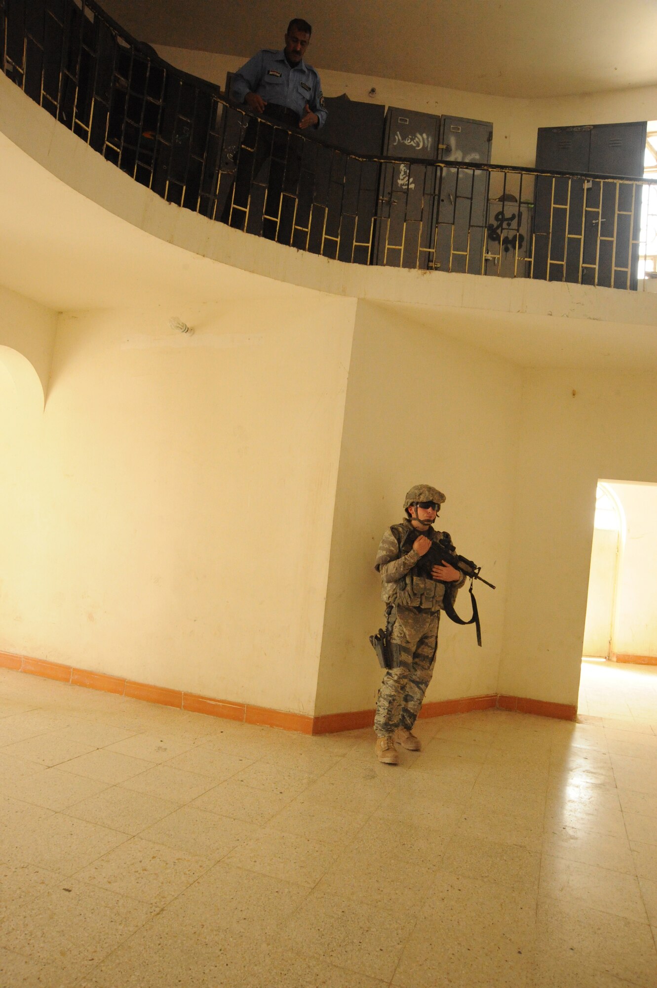 Air Force Senior Airman Brett Peterson, 732nd Expeditionary Security Forces Squadron Detachment 2, stands watch as an Iraqi police officer looks below at a local Iraqi police station before beginning a joint presence patrol near Rufush, Iraq, April 4, 2010.  The 732nd Expeditionary Security Forces, Detachment 2, conducted a “training and mentoring” mission, which was requested by the local police. During this mission, Air Force personnel trained the police in community policing and assisted with patrolling through a village recently overwhelmed by terrorist attacks. (U.S. Air Force photo/Master Sgt. Trish Bunting/Released)
