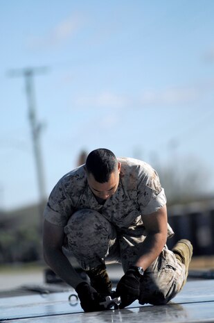 U.S. Marine Lance Cpl. Garren Robinson locks two air cargo pallets together in preparation for the loading of a mine-resistant, ambush-protected all-terrain vehicle at the 437th Aerial Port Squadron March 23, 2010, on Joint Base Charleston, S.C. The M-ATVs are owned by the Marine Corps and are being transported downrange to support Operation Enduring Freedom. Corporal Garren is with the 4th Marine Logistics Group, 4th Atlanta Support Battalion, Charlie Company. (U.S. Air Force photo/Senior Airman Timothy Taylor)