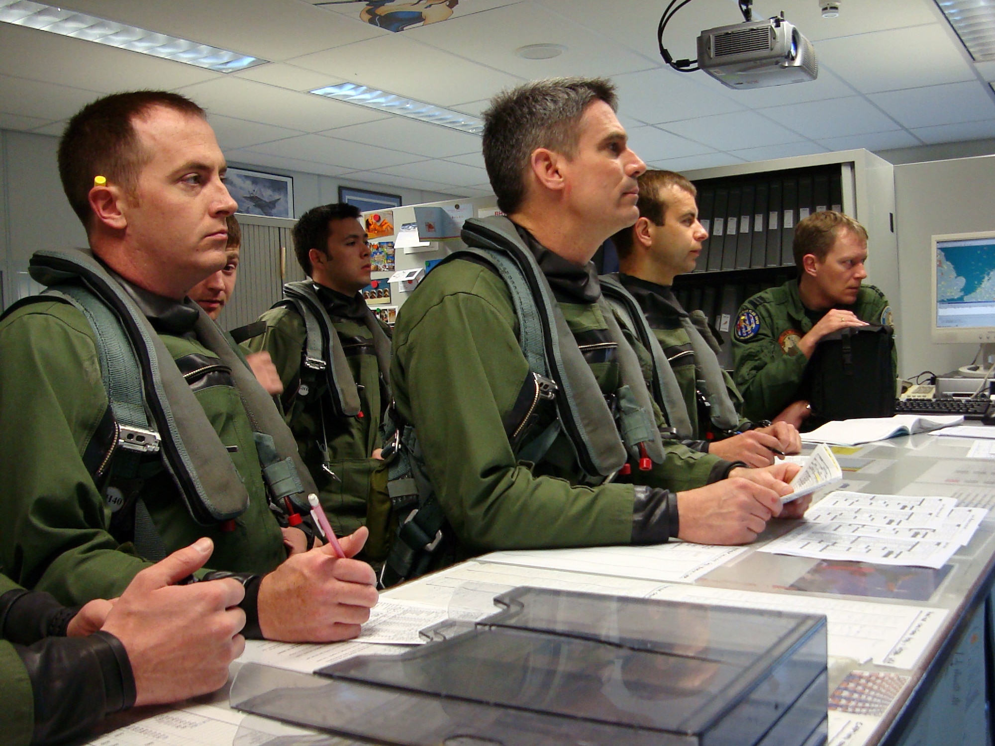 Lt. Col. Michael King (center), 493rd Fighter Squadron commander, and other pilots are briefed at the operations desk before their training mission April 13 during FRISIAN FLAG 2010 at Leeuwarden Air Base, The Netherlands.  In addition to the RAF Lakenheath personnel and U.S. Air Force F-15Cs, other nations and aircraft participating in this exercise include Dutch F-16s, Swedish JAS-39s, Finnish F-18s, Norwegian F-16s, German F-4s and Polish F-16s. (U.S. Air Force photo/1st Lt. Haley Ageton) 

