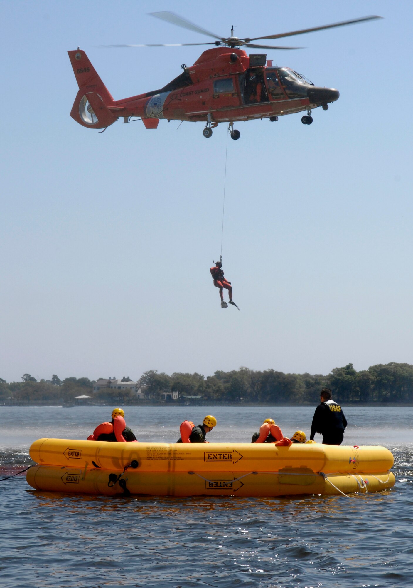 A U.S. Coast Guard rescue diver is lowered into the Charleston Harbor in Charleston, S.C., from a helicopter during a Survival, Evasion, Resistance and Escape refresher course for aircrew from Joint Base Charleston, S.C., April 5, 2010. The Coast Guard and Air Force team-up for joint training twice a month to teach the aircrew members how to survive in the event of an aircraft emergency. The Coast Guard uses the water survival class as an opportunity to train their rescue divers how to lift victims out of the water and administer proper care. (U.S. Air Force Photo/Airman 1st Class Lauren Main)
