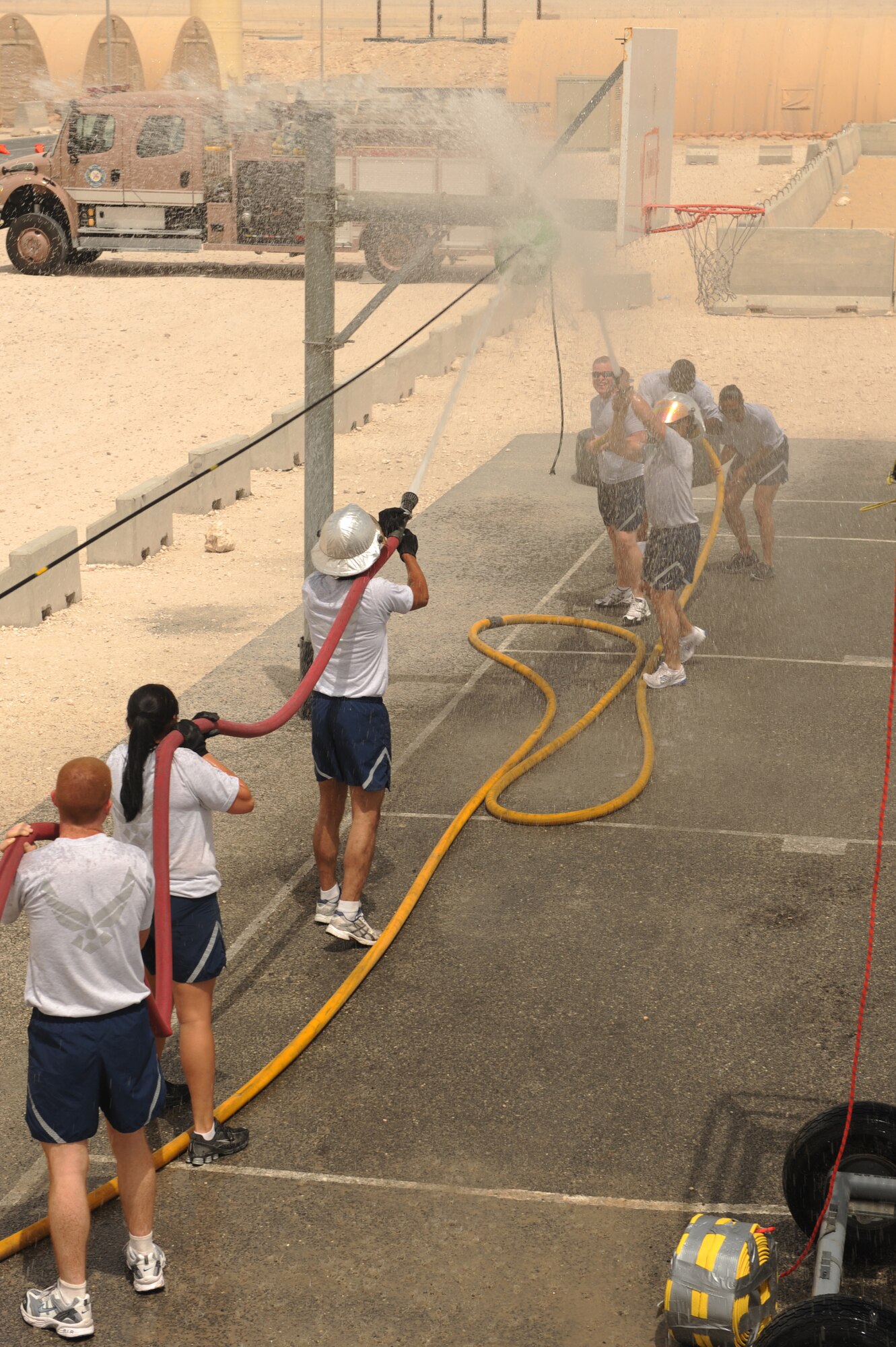 The 379th Expeditionary Logistics Readiness team (left) competed against the 379th Expeditionary Force Support Squadron team in a fire hose competition during base firefighter games at a non-disclosed Southwest Asia location, Apr 10, 2010. (U.S. Air Force photo by Tech. Sgt. Michelle Larche)[RELEASED]