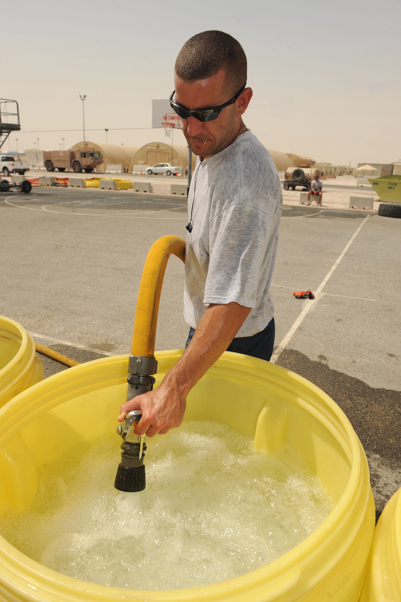 Staff Sgt. James Taylor, 379th Expeditionary Civil Engineer Squadron fire department crew chief, refills water drums during firefighter games at a non-disclosed Southwest Asia location, Apr 10, 2010. (U.S. Air Force photo by Tech. Sgt. Michelle Larche)[RELEASED]