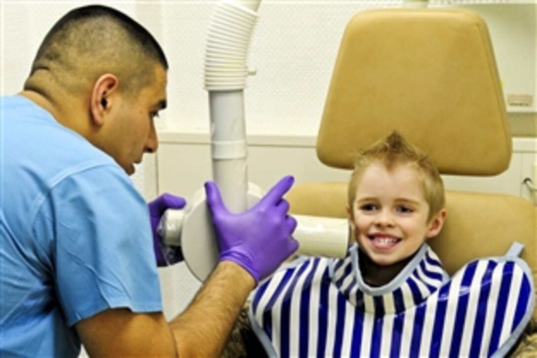 U.S. Air Force Senior Airman Alejandro Juarez  X-rays the back teeth of a child of a U.S. airman on Ramstein Air Base, Germany, April 12, 2010. Juarez is a dental assistant journeyman assigned to the 86th Dental Squadron, which serves about 200 children and their families in the Kaiserslautern Military Community during their biannual event, "Little Teeth, Big Smiles."