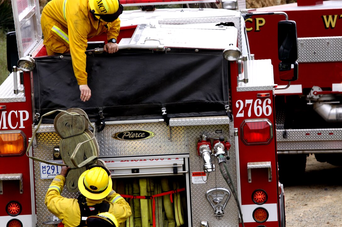 Firefighters with Camp Pendleton’s Fire and Emergency Services unload hoses during the department’s first Multi-company Hoselay and Rule of Engagement Drill at Camp Pendleton, April 14. More than 130 firefighters from the base’s 11 fire stations participated in the special exercise, April 14 - 16. The drill took firefighters through simulated wildfire scenarios that forced them to negotiate steep and virtually inaccessible terrain, in preparation for the fast approaching fire season.