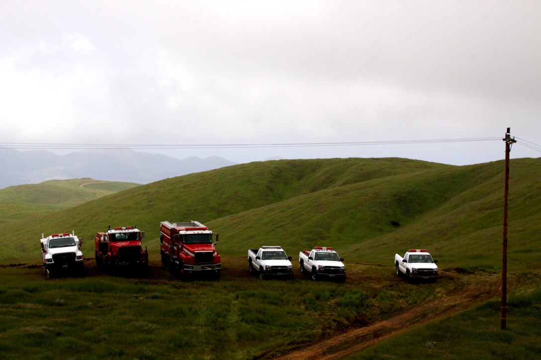 Fire trucks are staged in a remote area of Camp Pendleton for the fire department’s first consolidated Multi-company Hoselay and Rule of Engagement Drill, April 14. More than 130 firefighters from the base’s 11 fire stations participated in the special exercise, April 14 - 16. Nearly every firefighter carried, and progressively ran, a total of 1,800 pounds of hoses through densely brushed hills with elevations exceeding 2,300 feet during the three-day drill. The trainees broke into 40-man teams and simulated typical wild-land fire scenarios to maintain vital wildfire fighting techniques.