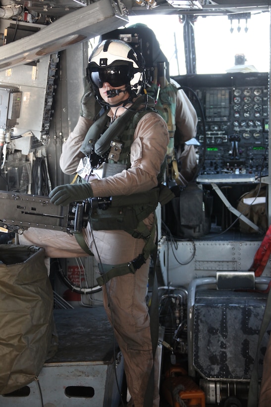 Cpl. Danny A. Snyder, an airframer technician and aerial observer with Marine Heavy Helicopter Squadron 366, communicates with his crew chief during aerial-gunners training at bombing target 9, April 15. The Marines fired .50-caliber machine guns at stationary targets as part of their combat training.