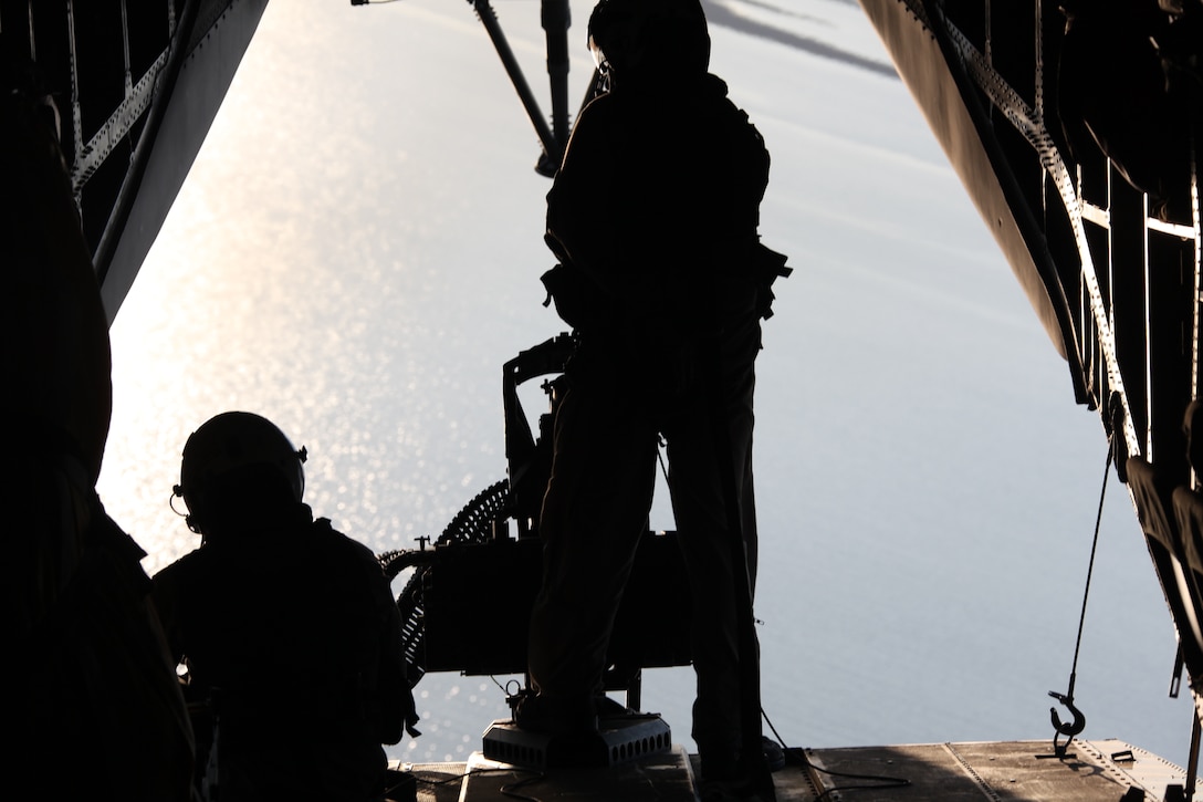 Staff Sgt. Timothy P. O’Connor, a weapons and tactics instructor with Marine Heavy Helicopter Squadron 366, and Sgt. Enrique Zamora, a CH-53E crew chief with HMH-366, prepare their .50-caliber machine gun while flying out to the training area at bombing target 9, April 15. O’Connor instructed Zamora and two other Marines as they shot the three helicopter-mounted machine guns.