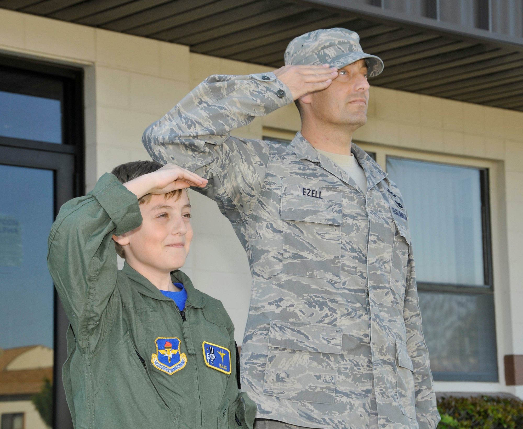 Tech. Sgt. Joe Ezell and son Isaac, salute the flag during Retreat, which signifies the end of the day April 9, 2010, at Tyndall Air Force Base, Fla. Isaac recently participated in the Tyndall AFB Pilot for a Day program. Sergeant Ezell is a 601st Air and Space Operations Center operational assessments technician. (U.S. Air Force photo/Lisa Norman)
