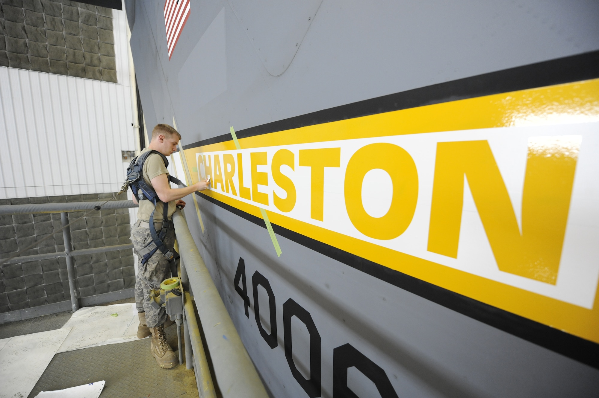 U.S. Air Force Airman 1st Class Mark Staley applies a squeegee to a Charleston stencil to ensure good connectivity April 15, 2010, at Joint Base Charleston, S.C. After the stencil is applied the letters are painted to highlight the word "Charleston." Airman Staley is an aircraft structural maintainer with the 437th Maintenance Squadron. (U.S. Air Force photo by James M. Bowman/released)