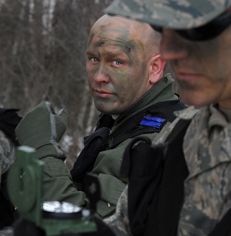 ELMENDORF AIR FORCE BASE, Alaska -- Master Sgt. Andrew Schultz watches as Capt. Andrew Hull uses the compass to guide their team in the right direction during survival, evasion, resistance and escape field training operations April 12. SERE field training operations training covers hands on learning with maps, GPS units and radios. Captain Hull is an airborne surveillance officer and Sergeant Schultz is a communications system operator, both are with the 962nd Airborne Air Control Squadron. (Air Force photo by Senior Airman Cynthia Spalding)