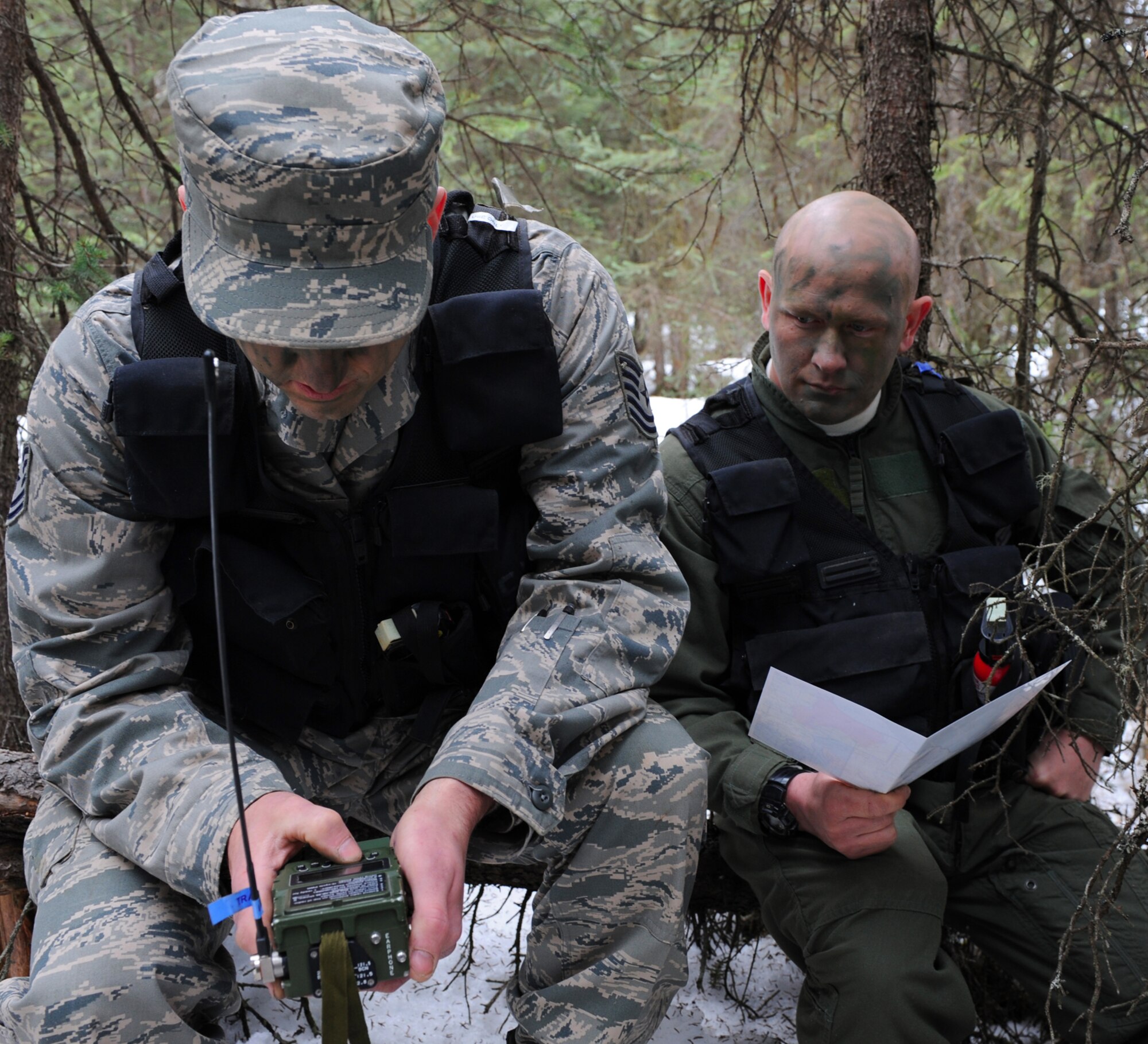 ELMENDORF AIR FORCE BASE, Alaska -- Tech. Sgt. Andrew Reich and Master Sgt. Andrew Schultz coordinate back and forth on their radio to complete land navigation training April 2.  Survival, evasion, resistance and escape field training operations training covers hands on learning with maps, GPS units and radios. Sergeant Reich and Sergeant Schultz are communications system operators with the 962nd Airborne Air Control Squadron.  (Air Force photo by Senior Airman Cynthia Spalding)