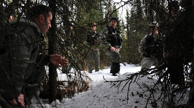 ELMENDORF AIR FORCE BASE, Alaska -- Tech. Sgt. Drew Timms demonstrates to members of the 962nd Airborne Air Control Squadron how to conceal themselves into their surrounding environment April 12. This combat survival course is required every three years for members assigned to the 962nd AACS. Sergeant Timms is a survival, evasion, resistance and escape specialist with the 3rd Operation Support Squadron Weapons and Tactics Flight. (Air Force photo by Senior Airman Cynthia Spalding)