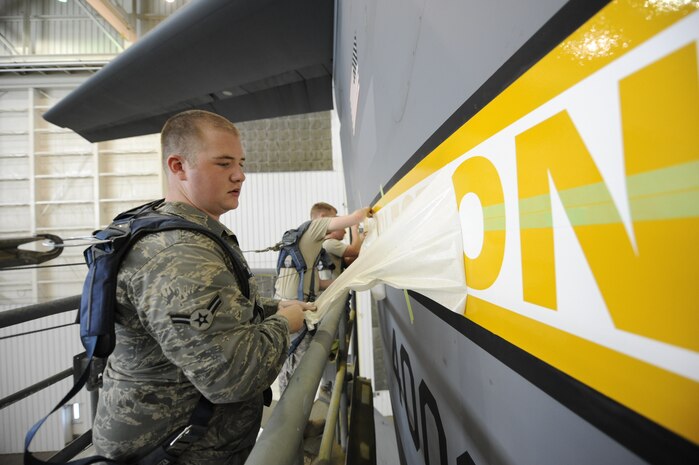 U.S. Air Force Airman 1st Class Cory Pfantz peels back a Charleston stencil from its backing April 15, 2010, at Joint Base Charleston, S.C. Removing the stencil allows Airmen to apply the Charleston letters to the aircraft to be painted. Airman Pfantz is an aircraft structural maintenance journeyman with the 437th Maintenance Squadron. (U.S. Air Force photo/James M. Bowman/released))