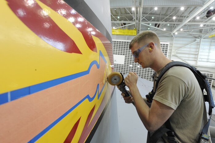 U.S. Air Force Airman 1st Class Mark Staley removes an Altus C-17 tail flash with an air operated decal remover April 12, 2010, at Joint Base Charleston, S.C. Removing the the old tail flash vinyl is the first step on transforming the aircraft into a Charleston C-17. Airman Staley is an aircraft structural maintenance journeyman with the 437th Maintenance Squadron. (U.S. Air Force photo by James M. Bowman/released)