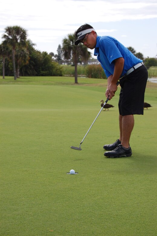 Airman 1st Class Roberto Herrera, a technical applications specialist for the Air Force Technical Applications Center Materials Technology Directorate, putts during a practice on the Patrick AFB Golf Course. Herrera, a new addition to the base golf team, scored a double eagle (sunk the ball on the second shot of a par 5) from the blue tees on the 6th hole of the course April 4.  (U.S. Air Force photo/Master Sgt. Patrick Murphy)