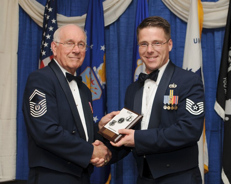 McGHEE TYSON AIR NATIONAL GUARD BASE, Tenn. -- Tech. Sgt. Jason W. Baedke, Scott AFB, Ill., receives the distinguished graduate award for NCO Academy Class 10-4 at The I.G. Brown Air National Guard Training and Education Center here from retired Chief Master Sergeant of the Air Force Sam E. Parish, April 7, 2010. The distinguished graduate award is presented to students in the top ten percent of the class.  It is based on objective and performance evaluations, demonstrated leadership, and performance as a team player. (U.S. Air Force photo by Master Sgt. Kurt Skoglund/Released)